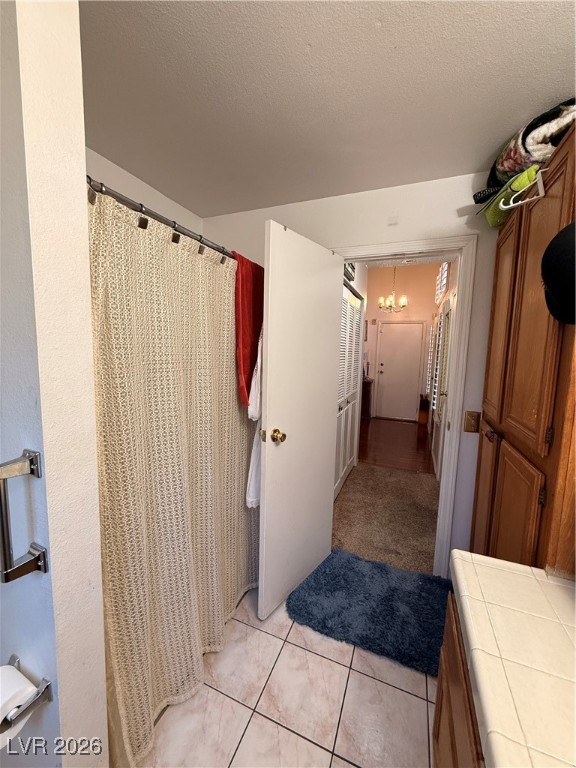 6425 West Eagle Point Road Las Vegas, NV 89108 - Photo 16 of 42 Bathroom with curtained shower, a textured ceiling, and a chandelier