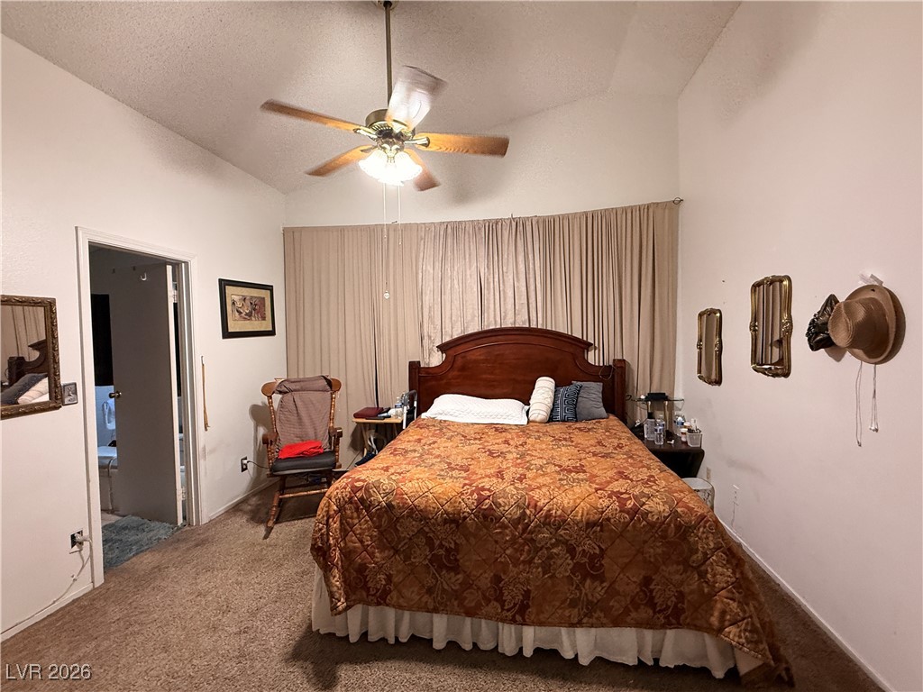 6425 West Eagle Point Road Las Vegas, NV 89108 - Photo 29 of 42 Carpeted bedroom featuring lofted ceiling, a textured ceiling, and a ceiling fan