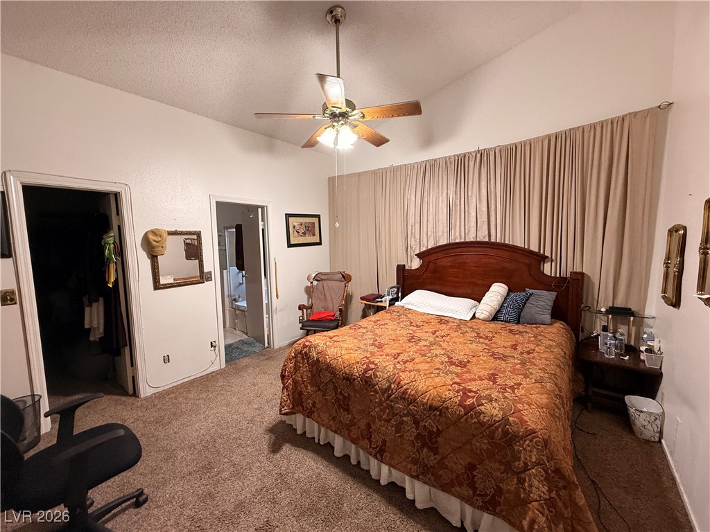 6425 West Eagle Point Road Las Vegas, NV 89108 - Photo 30 of 42 Carpeted bedroom with a spacious closet, lofted ceiling, a textured ceiling, ceiling fan, and ensuite bath