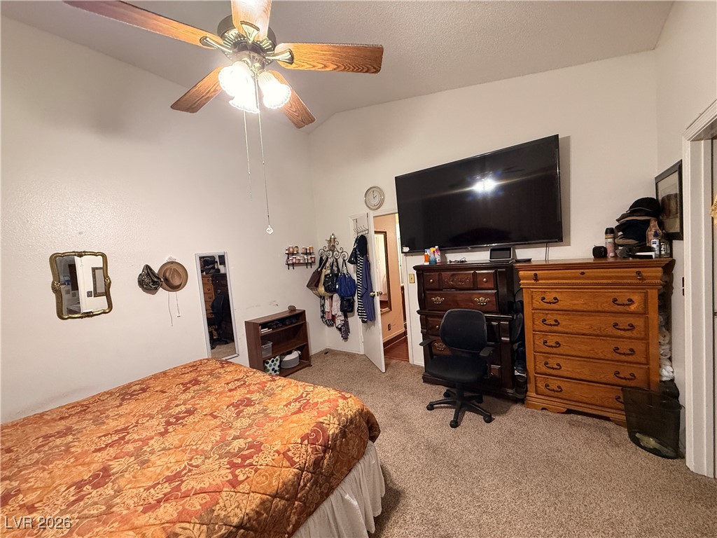 6425 West Eagle Point Road Las Vegas, NV 89108 - Photo 32 of 42 Bedroom with lofted ceiling, light colored carpet, a ceiling fan, and a textured ceiling