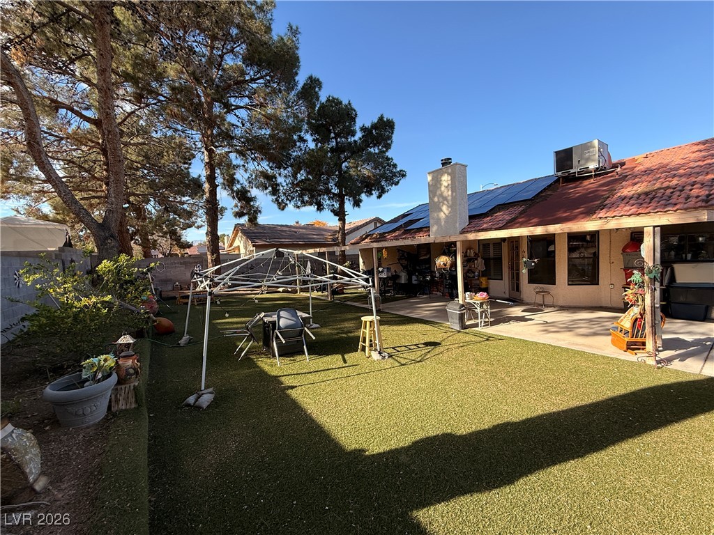 6425 West Eagle Point Road Las Vegas, NV 89108 - Photo 38 of 42 Rear view of house featuring a chimney, a patio area, and solar panels