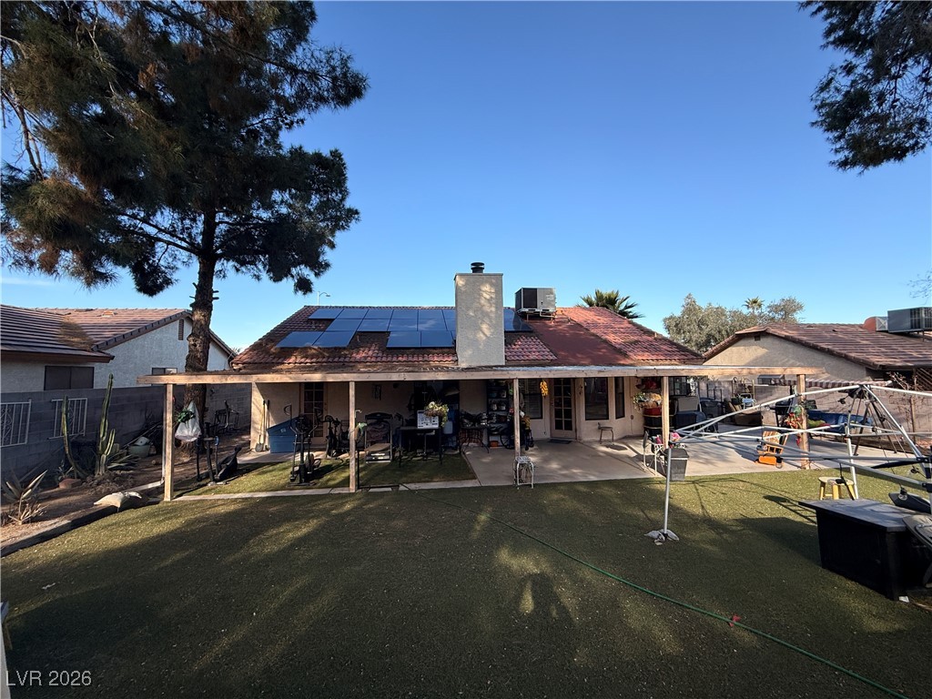 6425 West Eagle Point Road Las Vegas, NV 89108 - Photo 40 of 42 Back of house featuring solar panels, a patio, a chimney, and a fenced backyard