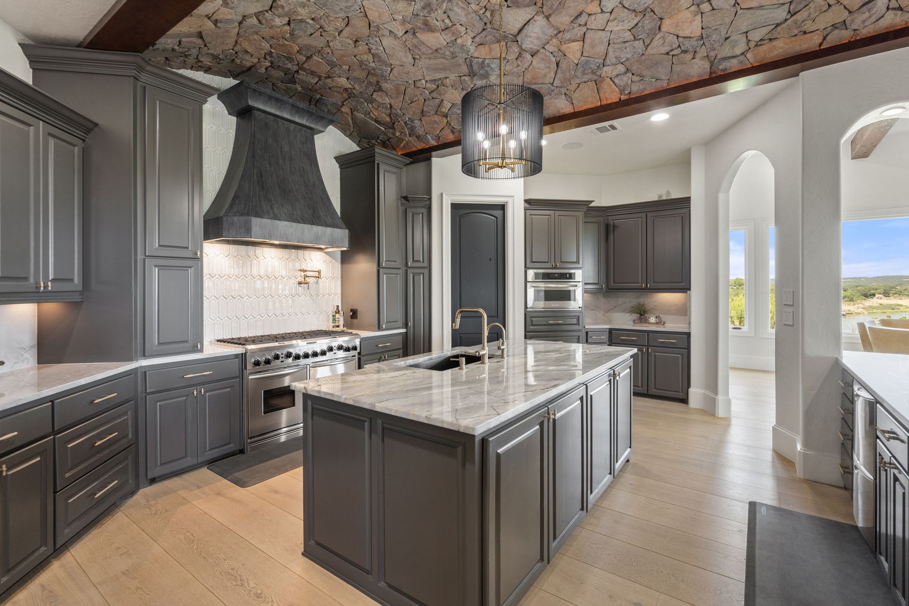 1216 Travis Bluff Way Spicewood, TX 78669 - Photo 11 of 38 a kitchen with stainless steel appliances granite countertop a sink and a stove