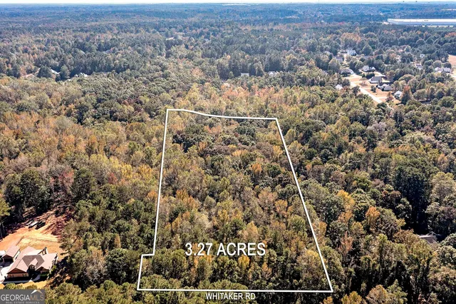 an aerial view of house with yard and mountain view in back