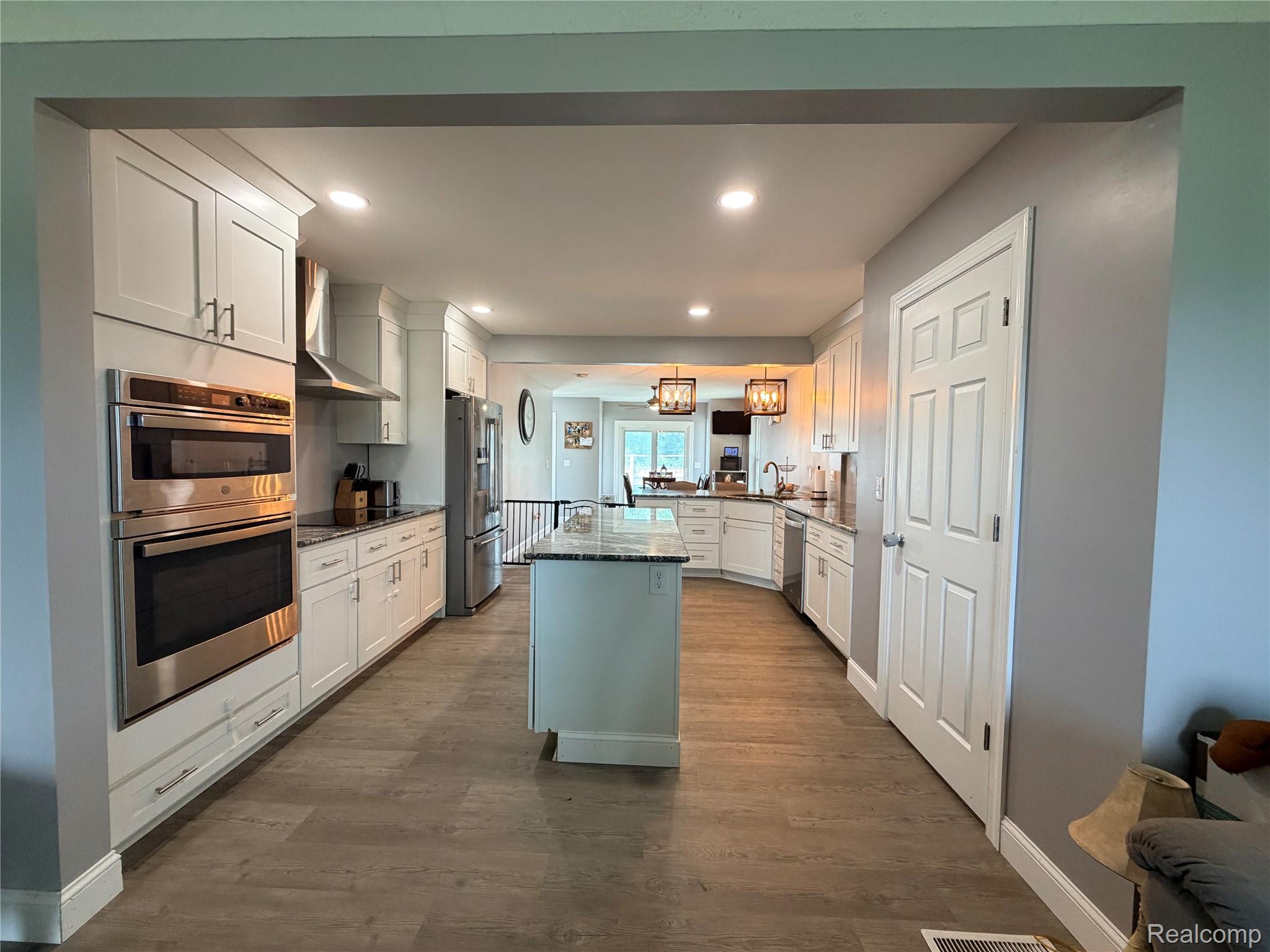 3840 East Dunbar Road Monroe, MI 48161 - Photo 16 of 38 Spacious kitchen featuring white shaker cabinetry, stainless steel appliances, a central island, recessed lighting, and wood-finish flooring