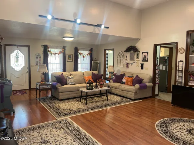 a living room with furniture and a wooden floor