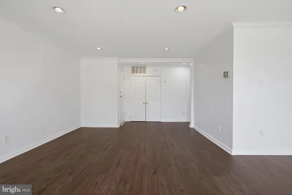 a view of an empty room with wooden floor