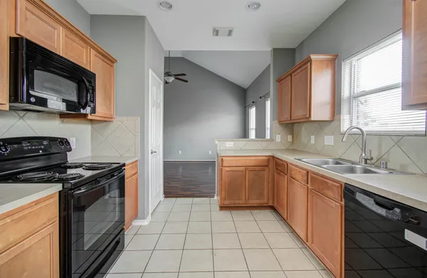 a kitchen with a sink stove top oven and cabinets