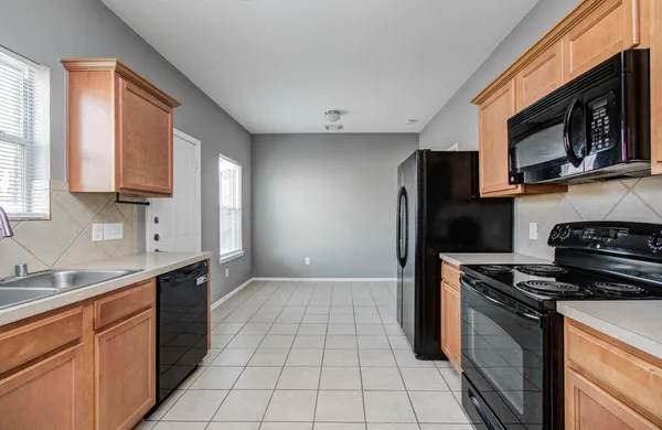 a kitchen with stainless steel appliances a sink a stove a microwave a sink and cabinets