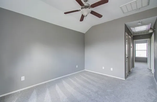 a view of an empty room and window and a ceiling fan
