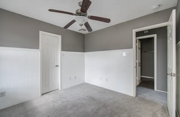 an empty room with a window and a fan