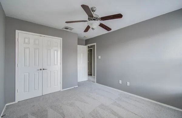 an empty room with a window and a ceiling fan