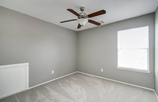 an empty room and chandelier fan