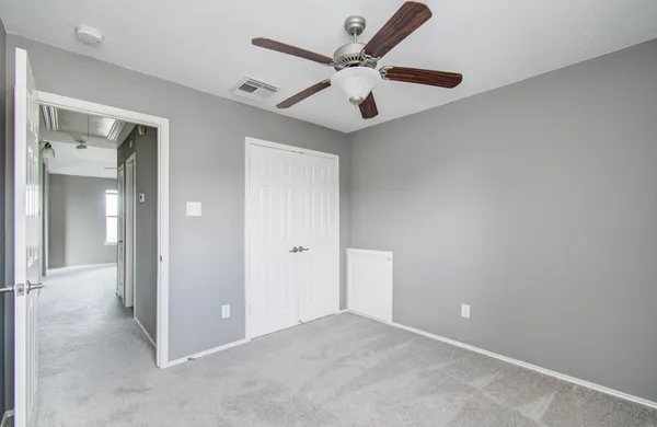 an empty room and chandelier fan