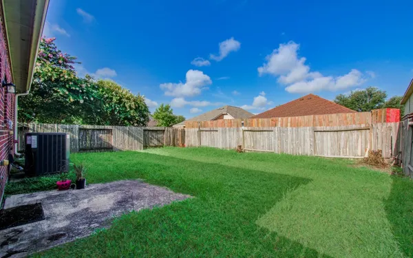 a view of a backyard with plants and wooden fence