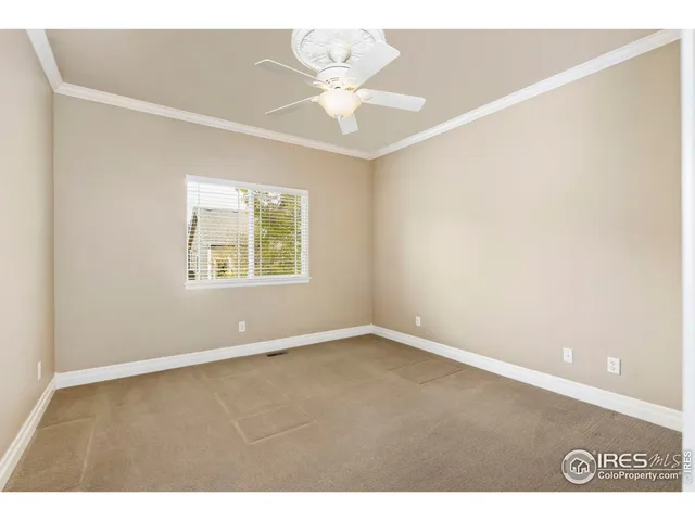 an empty room with windows and chandelier fan