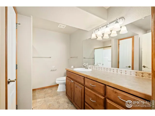 a bathroom with a granite countertop sink a large mirror and a shower