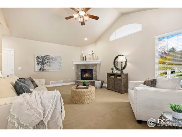 a living room with furniture a fireplace and a large window