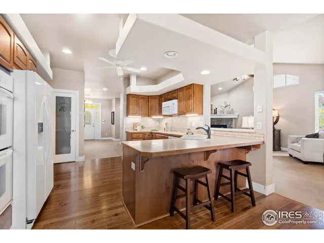 a kitchen with stainless steel appliances kitchen island granite countertop a table chairs and a refrigerator