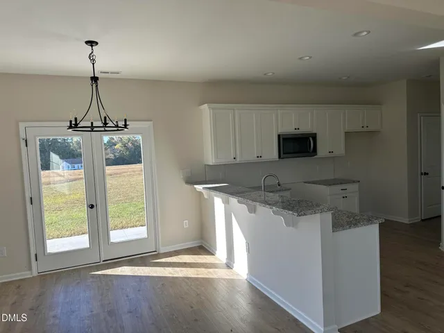 a kitchen with stainless steel appliances granite countertop a sink and a wooden floor