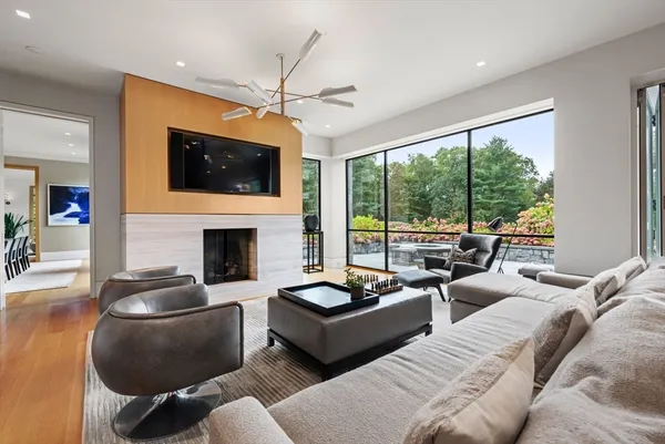 a living room with furniture a fireplace and a large window