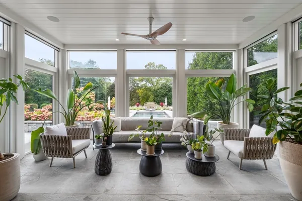 a living room with furniture and potted plants