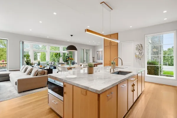 a view of kitchen island with stainless steel appliances granite countertop sink and living room view