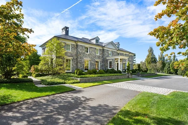 a view of a big building with a big yard and large trees