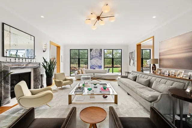 a living room with furniture a fireplace and a large window
