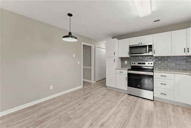 a kitchen with granite countertop a stove and a refrigerator