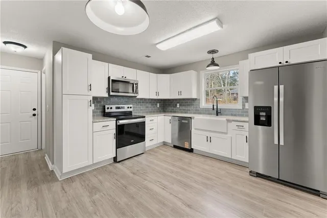 a kitchen with stainless steel appliances a refrigerator sink and microwave