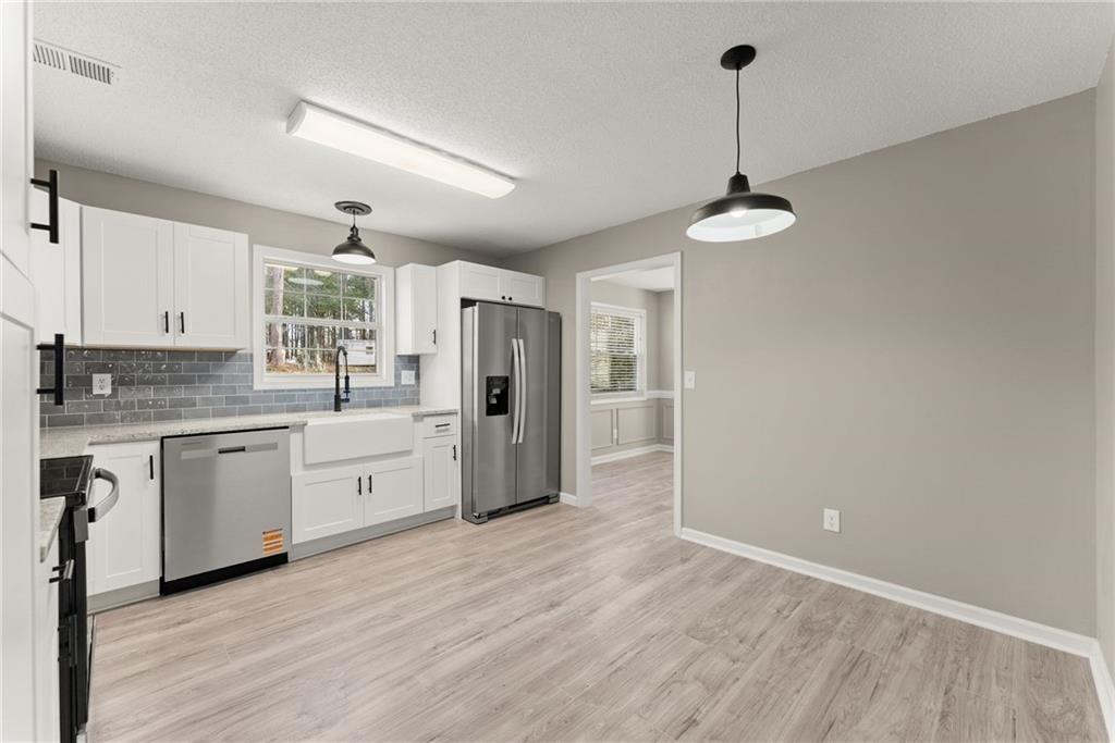 604 Fox Run Winder, GA 30680 - Photo 17 of 38 a open kitchen with stainless steel appliances granite countertop a refrigerator a sink dishwasher a stove and white countertops with wooden floor