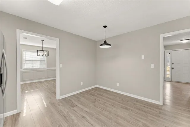 an empty room with wooden floor and window