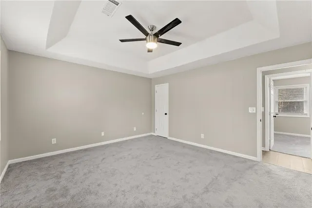 an empty room with closet and ceiling fan