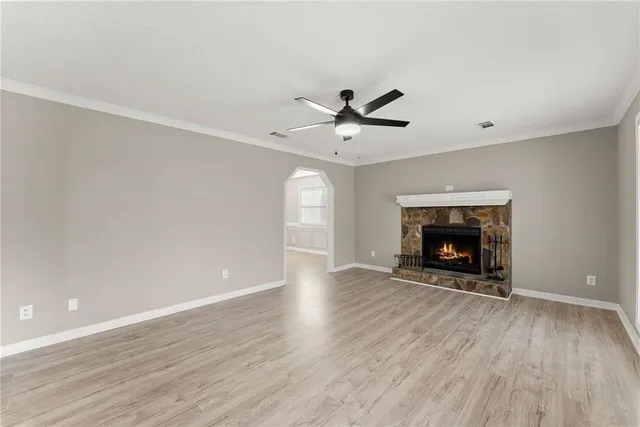 an empty room with windows a fireplace