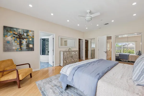 a spacious bedroom with a large bed couch and a window