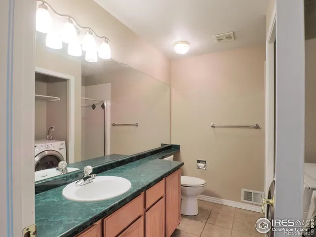 a bathroom with a granite countertop sink toilet a mirror and shower