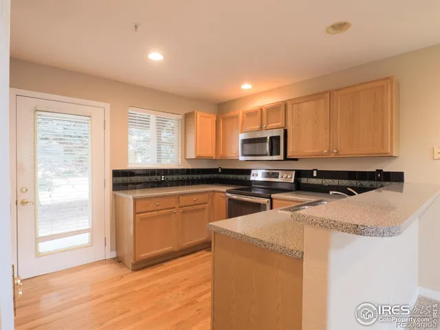 a kitchen with stainless steel appliances granite countertop a stove a sink and a microwave