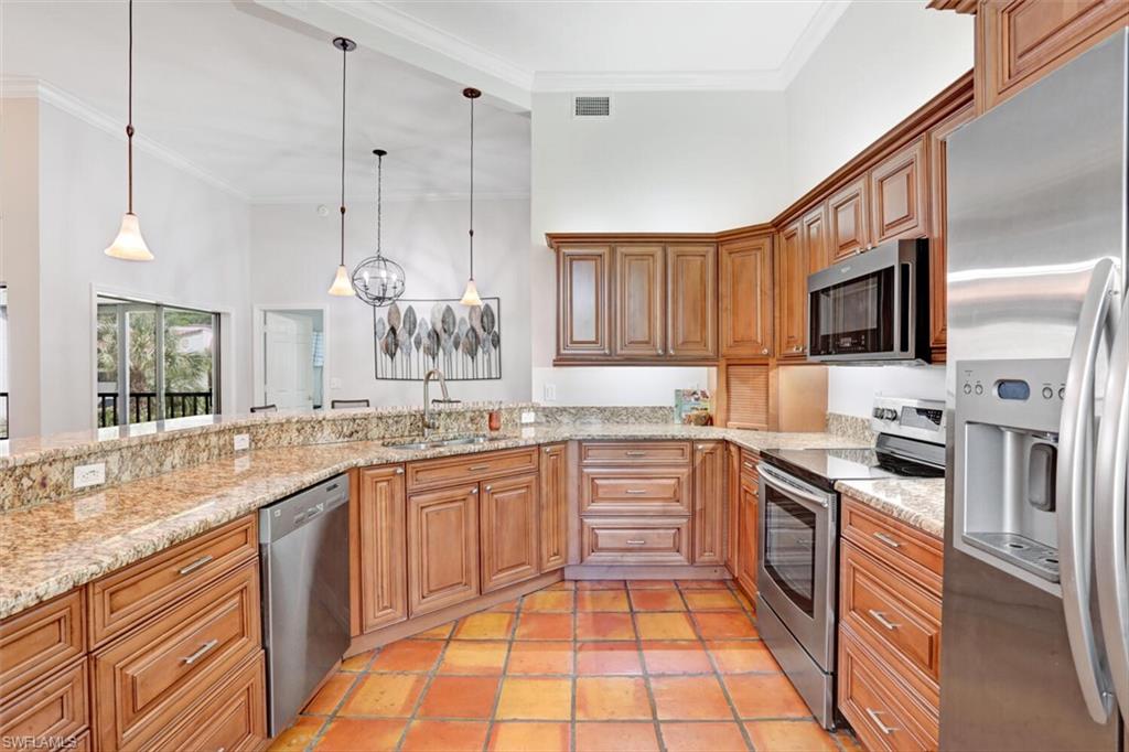 6535 Valen Way, Unit E202 Naples, FL 34108 - Photo 12 of 33 a large kitchen with granite countertop a sink and dishwasher a stove top oven with wooden floor