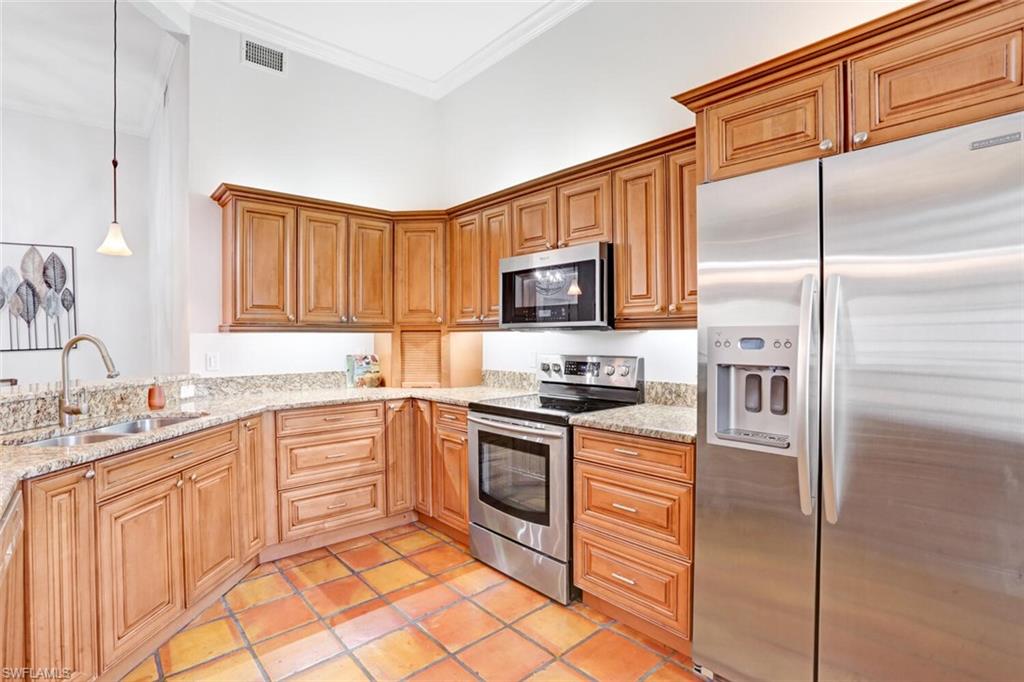 6535 Valen Way, Unit E202 Naples, FL 34108 - Photo 13 of 33 a kitchen with stainless steel appliances granite countertop a refrigerator stove top oven and sink