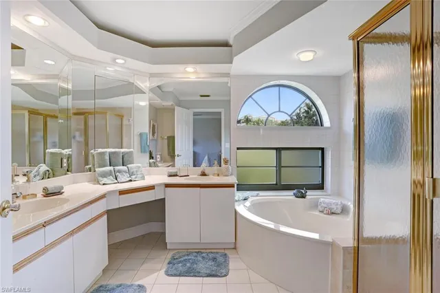 a bathroom with a sink a mirror and a bathtub with a double vanity sink