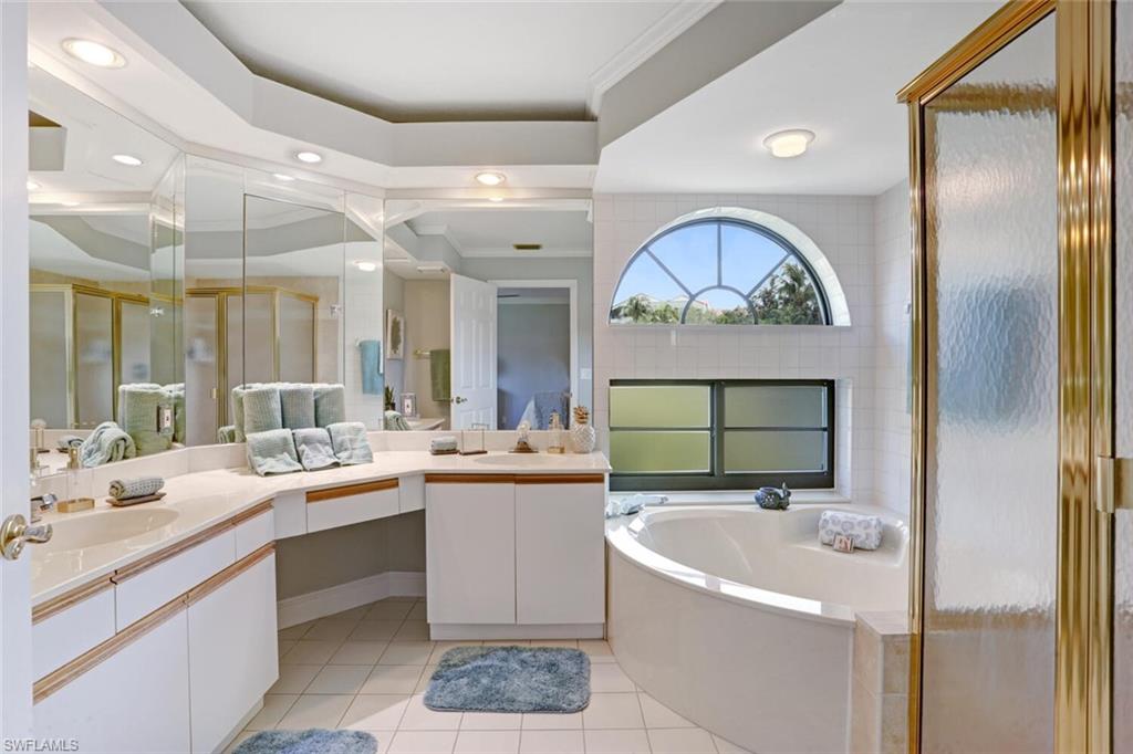 6535 Valen Way, Unit E202 Naples, FL 34108 - Photo 21 of 33 a bathroom with a sink a mirror and a bathtub with a double vanity sink