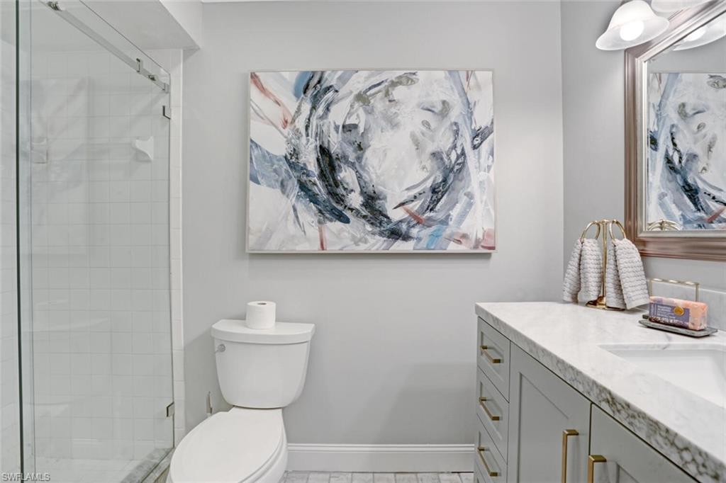 6535 Valen Way, Unit E202 Naples, FL 34108 - Photo 27 of 33 a bathroom with a toilet sink and vanity