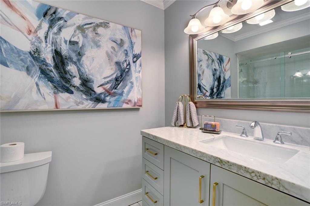 6535 Valen Way, Unit E202 Naples, FL 34108 - Photo 28 of 33 a bathroom with a sink and a mirror