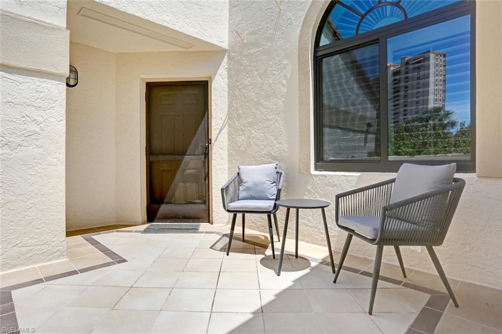 6535 Valen Way, Unit E202 Naples, FL 34108 - Photo 30 of 33 a balcony with two chairs and a potted plant