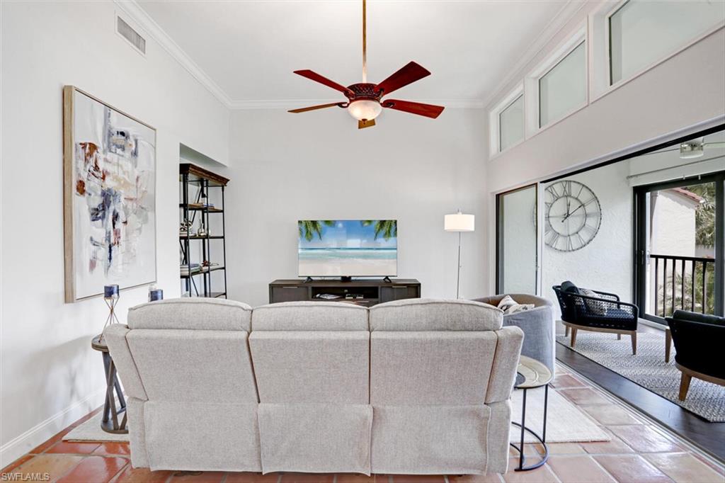 6535 Valen Way, Unit E202 Naples, FL 34108 - Photo 8 of 33 a living room with furniture a clock and a window