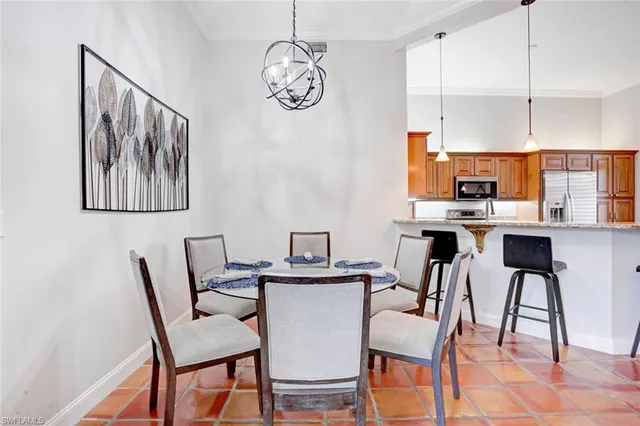 a view of a dining room with furniture a kitchen and chandelier