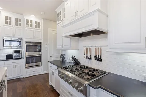 a kitchen with stainless steel appliances granite countertop a stove and a refrigerator