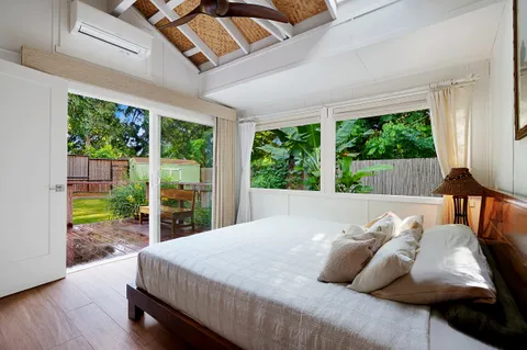 a bed sitting in a bedroom next to a window