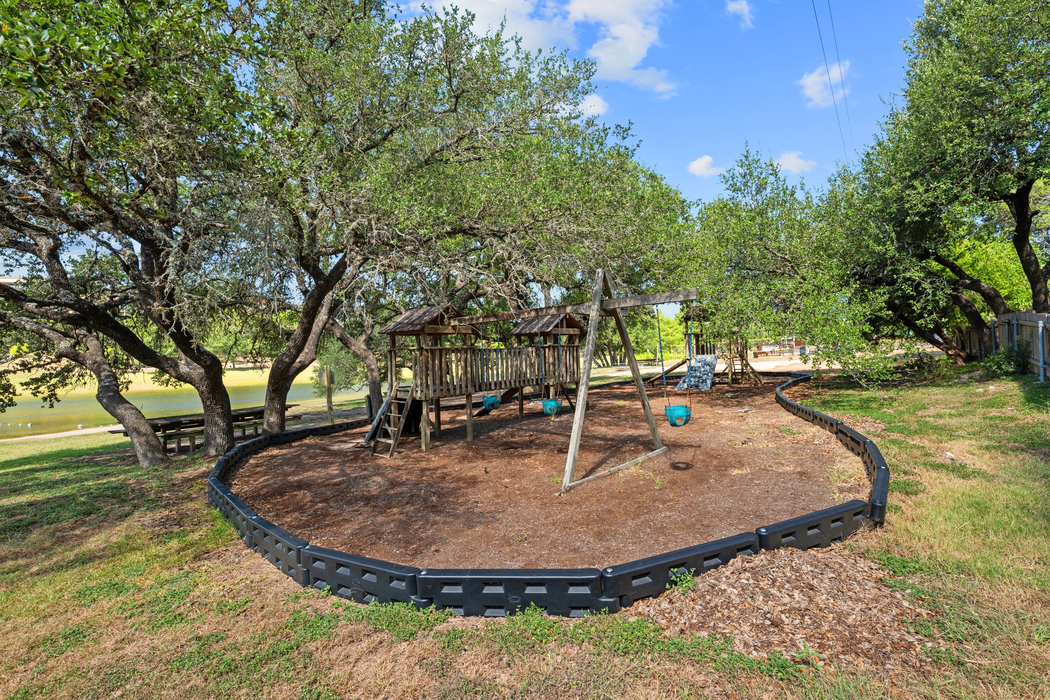 10114 Janet Loop Dripping Springs, TX 78620 - Photo 32 of 34 Mature shade trees frame a private playground area set along the water.